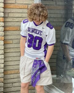 Model in vintage Nike Jr. Wolves football jersey and cream cargos with purple bandana